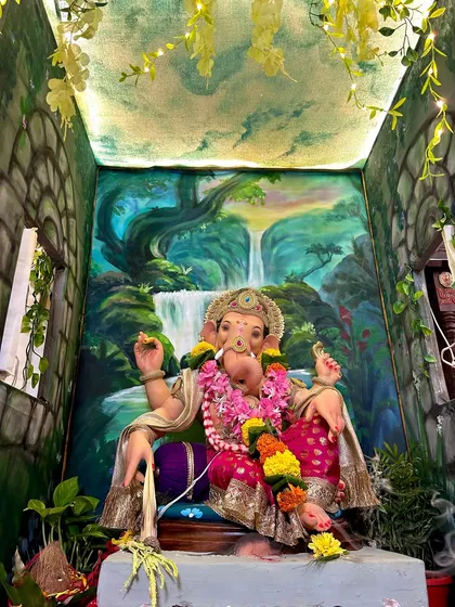 A different angle of the waterfall-themed decoration, showing the painted ceiling that adds to the immersive effect. The hanging vines with fairy lights make the space feel magical and alive.