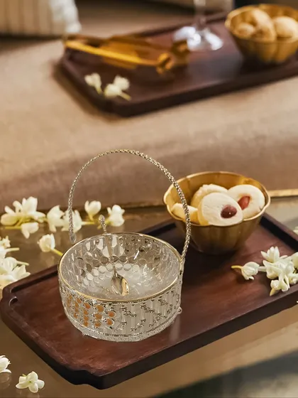 Our versatile peacock basket, shown here on a serving tray, is perfect for offering sweets or nuts to guests. Its compact size and elegant handle make it a practical and stylish addition to your serveware.