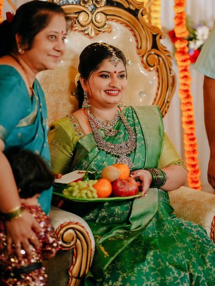 A beautiful candid moment from a Sreemantham, where the mother-to-be is presented with a plate of fruits as part of the ceremony, surrounded by loved ones.