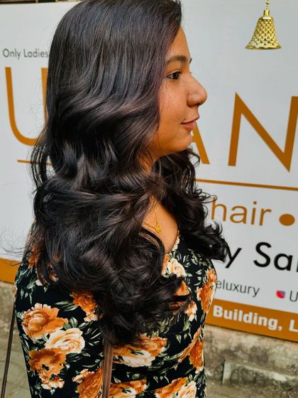 A side view of this beautiful global colour, styled with soft, bouncy waves that give it a romantic feel.