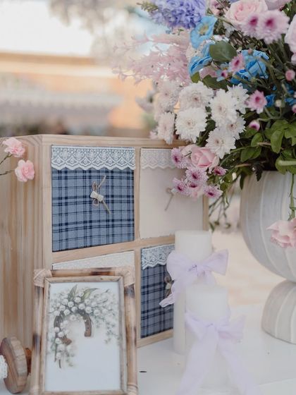 A close-up of a fabric-covered box with lace and ribbon details, part of a larger decorative vignette.