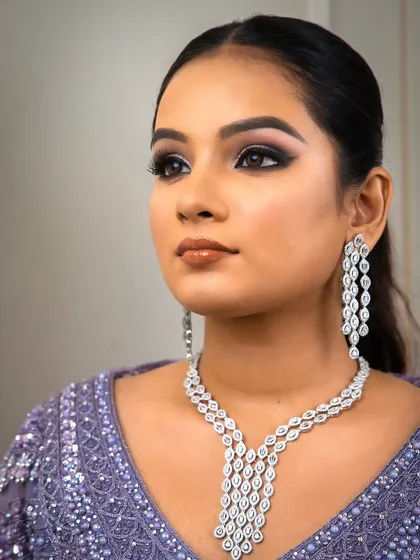 A close-up of a delicate zircon necklace set against a lavender lehenga. The intricate design and sparkling stones make this a perfect choice for a reception or engagement party.