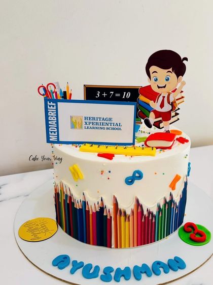 A fun school-themed cake with edible colored pencils and a student topper, celebrating a love for learning.