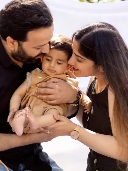 An intimate and loving portrait of parents kissing their baby's cheeks. These tender moments are the heart of our family photography sessions.