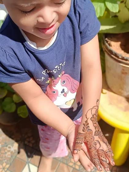 Here she is, admiring her finished mehendi stain in the sunlight. This photo shows how the organic henna paste develops into a beautiful, natural orange-brown color on the skin.