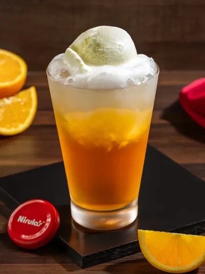 An orange ice cream soda, styled with fresh orange slices to emphasize its flavor.