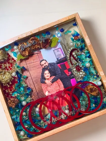 This design shows how we can incorporate different elements. I preserved the varmala, chuda, and other small ornaments alongside the couple's photo, creating a vibrant and personal memory box.
