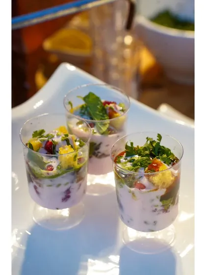 Small glasses of vibrant, layered chaat, ready to be served. These individual portions are perfect for parties and allow guests to enjoy the street food classic without the mess.