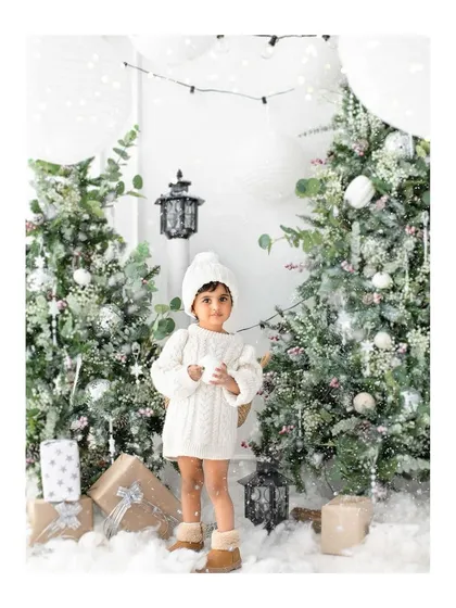A winter wonderland scene in my studio. This little one looks so sweet in her cozy white sweater, surrounded by snowy trees and soft light for her holiday portrait.