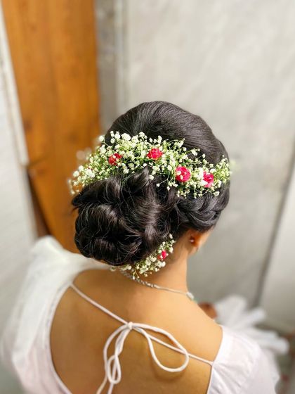 A detailed shot of the bridal hairstyle for my Buddhist bride. This intricate bun woven with delicate fresh flowers added a touch of romance and elegance to her overall look.