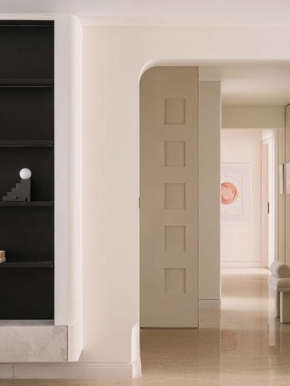 We used large sliding panels to demarcate private and open spaces, enhancing the home's utilitarian nature. This view through an arched doorway shows the dignified layering of materials and tonal consistency.
