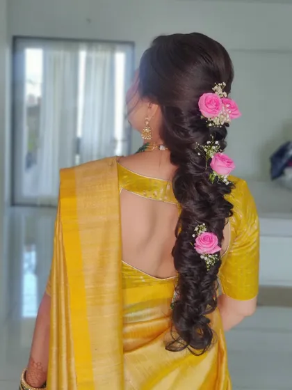 A beautiful messy fishtail braid decorated with fresh pink roses and baby's breath. This is a romantic and soft hairstyle, perfect for a pre wedding event.