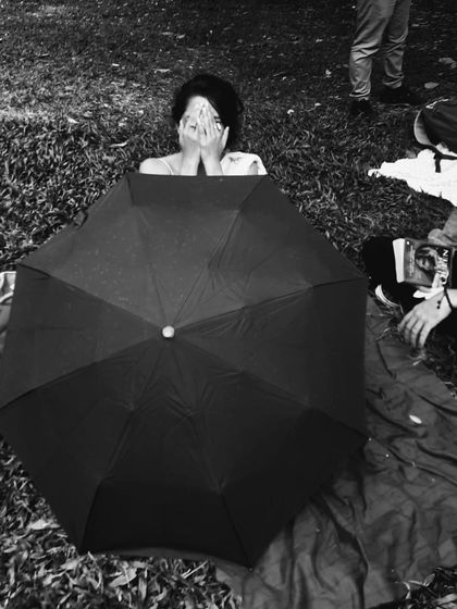 Writing under a black umbrella on a rainy day in the park. The weather doesn't stop the flow of words or the arrival of kind souls. This day was special as I completed my 108th poem, a milestone made possible by so much support.