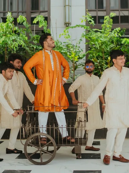 The groom and his groomsmen share a laugh, making a fun entry on a rustic cart. We love capturing the camaraderie and joy of the wedding party.