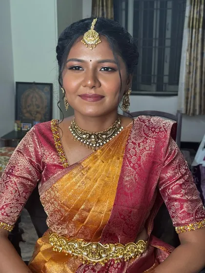 Gopika's final engagement look, showcasing how subtle makeup can make a beautiful impact. Her skin looks fresh and radiant, and the soft lip colour complements her traditional silk saree and antique jewellery.
