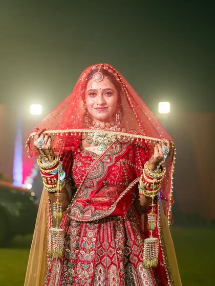 A beautiful portrait of the bride holding her veil. The soft lighting and her gentle smile create a timeless and elegant bridal shot.