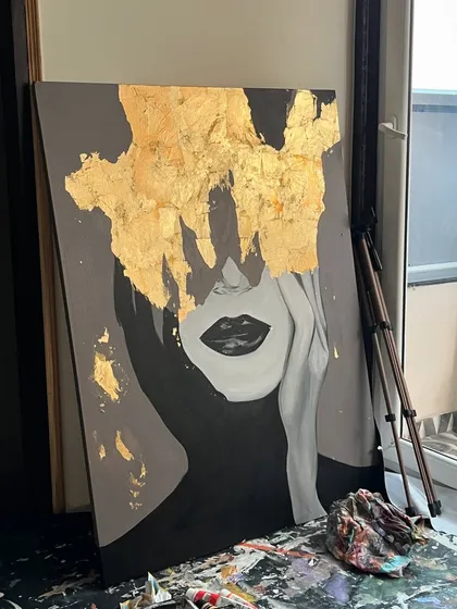 A bold and glamorous portrait painting featuring a face obscured by a cascade of 24ct gold leaf. This piece is a true statement-maker.