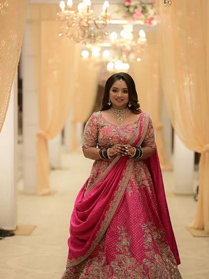 A happy client twirls in a vibrant pink lehenga with exquisite floral embroidery. Her joy is the reason I do what I do, curating pieces that make women feel beautiful and confident.