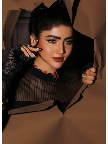 A creative and conceptual beauty shot, with the model peering through torn paper. This artistic approach is perfect for an editorial or a high-fashion makeup campaign.