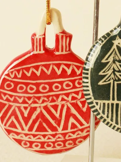 Close-up details of the intricate patterns carved and painted onto our handmade Christmas ornaments.