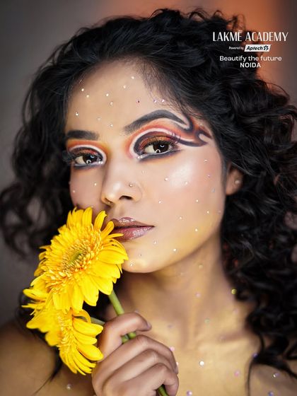 A beautiful portrait with sunflower-themed makeup. The glitter details and fresh flowers add a touch of magic to this sunny and creative look.