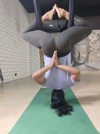 An inverted Baddha Konasana (Bound Angle Pose) in the aerial hammock. This variation allows for a deep hip opening without any pressure on the spine.