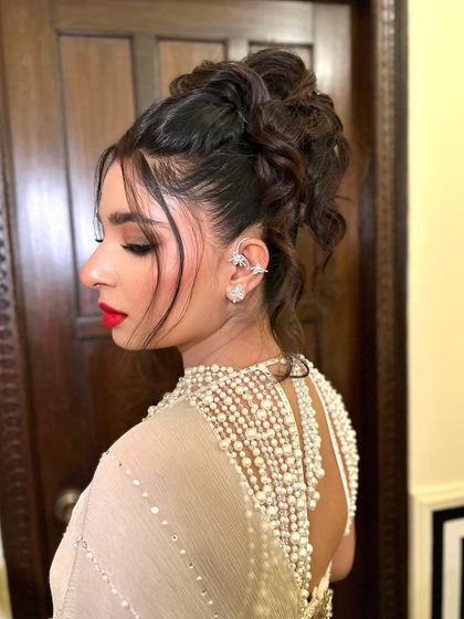 A side view of the modern tousled high bun, showing the texture and height that makes it a perfect reception hairstyle.