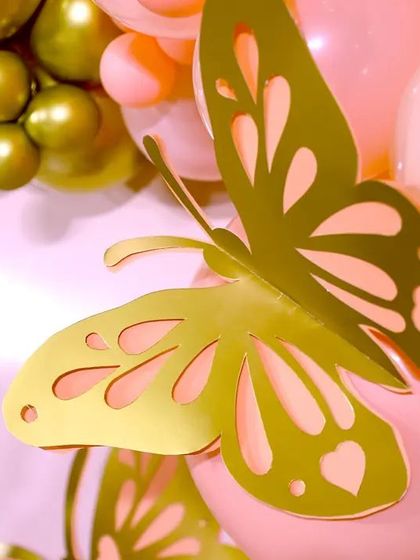 A detailed shot of a 3D golden butterfly accent on a balloon garland. These small, custom touches are what make our butterfly-themed parties so special and visually cohesive.