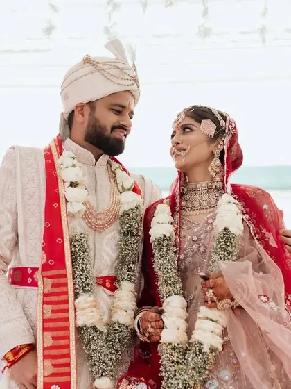 A moment of love and connection during the wedding ceremony. Adorned with garlands, the couple shares a quiet look that speaks volumes. These are the frames that capture the true essence of their bond.