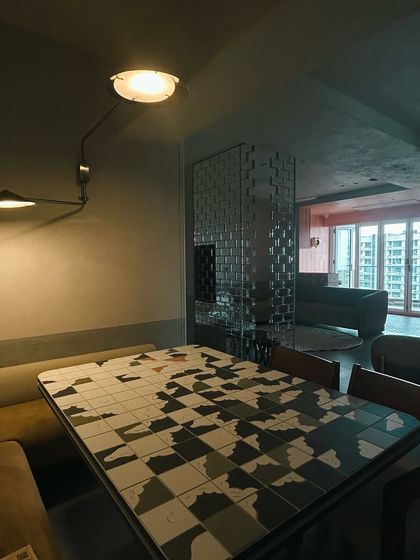 A candid shot from a recently completed project. This home has a retro, 1970s feel, with a tiled dining table and a mirrored room divider.