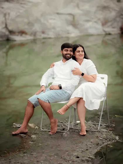 A creative pre-wedding shot where the couple sits on chairs in the water, creating a serene and slightly surreal portrait.
