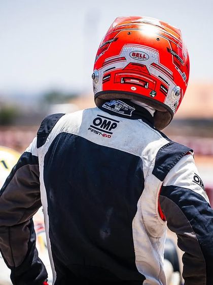A driver looks on from the grid, waiting for the race to start. This shot captures the focus and anticipation of a competitor.