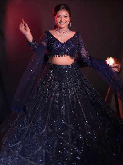 A full length view of the sparkling purple lehenga, showing how it creates a stunning silhouette. The matching sheer dupatta completes the look.