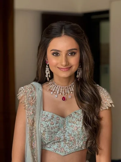A perfect look for an engagement or reception. I styled this bride's hair in soft, face-framing waves to complement her pastel lehenga and radiant makeup, creating an effortlessly elegant appearance.