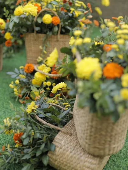 A cascade of marigolds and other flowers in cane baskets, used to decorate the event space.