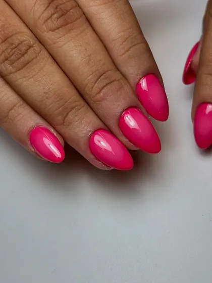 The vibrant pink airbrushed ombré nails, showing the flawless gradient on elegantly shaped almond extensions.