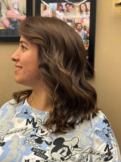A side view of a client's hair after a cut and color. The soft waves and fresh shade create a look that is both polished and effortlessly chic.