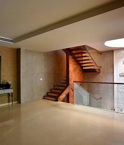 The upper landing is a spacious, gallery-like area, with the staircase and art wall serving as the main features.