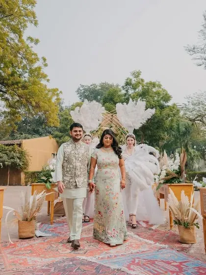 The couple's grand entrance, walking down an aisle lined with rustic decor and flanked by performers.