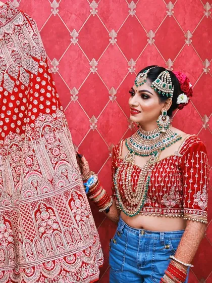 I believe fashion should tell your story. This shot captures the fun, modern side of a bride's journey, blending the traditional red lehenga with her everyday style. It’s a candid, personality-filled moment that adds a unique chapter to her wedding album.