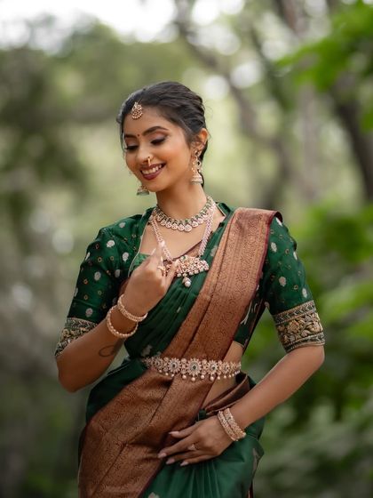 A close-up of the model, her smile as radiant as her beautiful green saree.