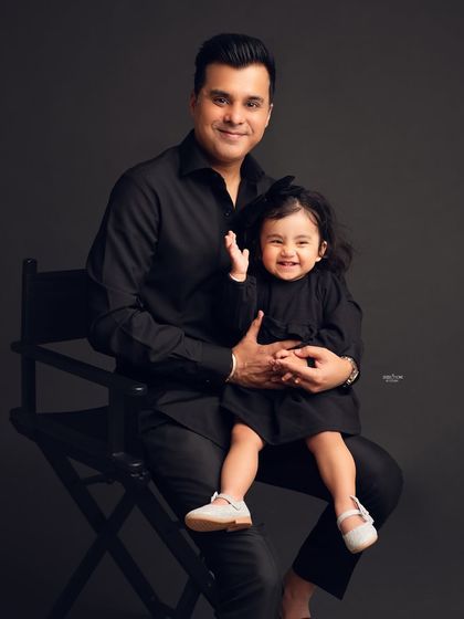 A happy father and daughter duo, twinning in black for their family photoshoot.