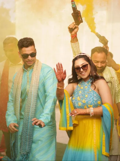 Making a grand entrance with color smoke. The bride's makeup is vibrant and fun, matching the energy of her Haldi celebration.
