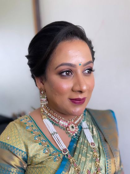 A side profile showing the clean, elegant updo and the beautiful jewelry.