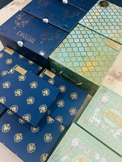 A stack of my beautiful Diwali gift boxes. The packaging is just as important as the treats inside, and I choose designs that feel festive and luxurious.