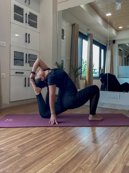 This image captures the essence of yoga as a path to freeing oneself from sorrow. The deep stretch in this advanced pose reflects the determination required in the practice.