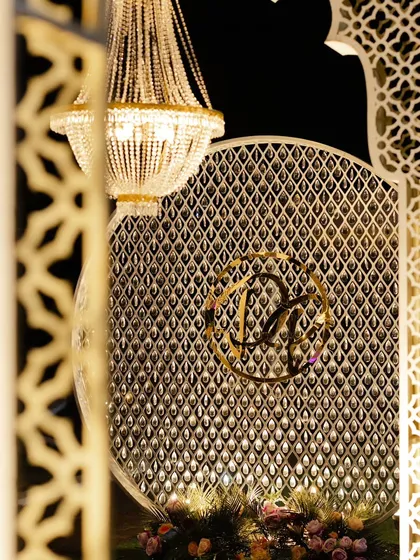 A close-up of a custom monogram for the couple, Devika and Prajay. This elegant detail was integrated into a larger backdrop, adding a sophisticated and personal touch to their reception decor.