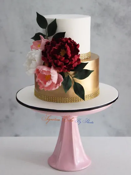This is one of my classic signature designs, combining a clean white and gold ganache finish with handmade sugar flowers. It’s a perfect example of the elegant style we can create.