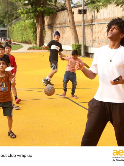 A high school volunteer from our 'Reach Out!' service club plays basketball with younger students from the Vivekanand Camp. The club focuses on building connections through sports, arts, and academic support.