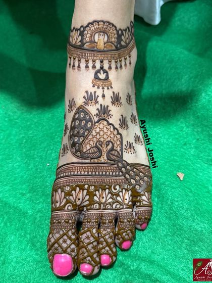 A beautiful foot design featuring peacocks and a representation of the Buddha, creating a serene and spiritual look.